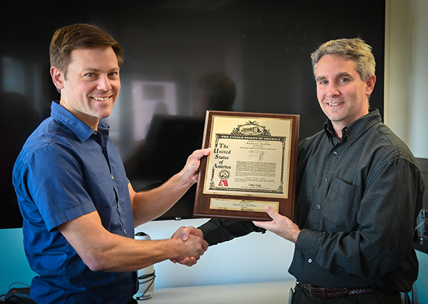 Rollins and Thur holding plaque